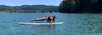 Sophomore Makenna Sawyer challenges herself by doing a plank on her stand-up paddle board during the SUP Series with Outdoor Pursuits on April 18. Photo courtesy of Makenna Sawyer.